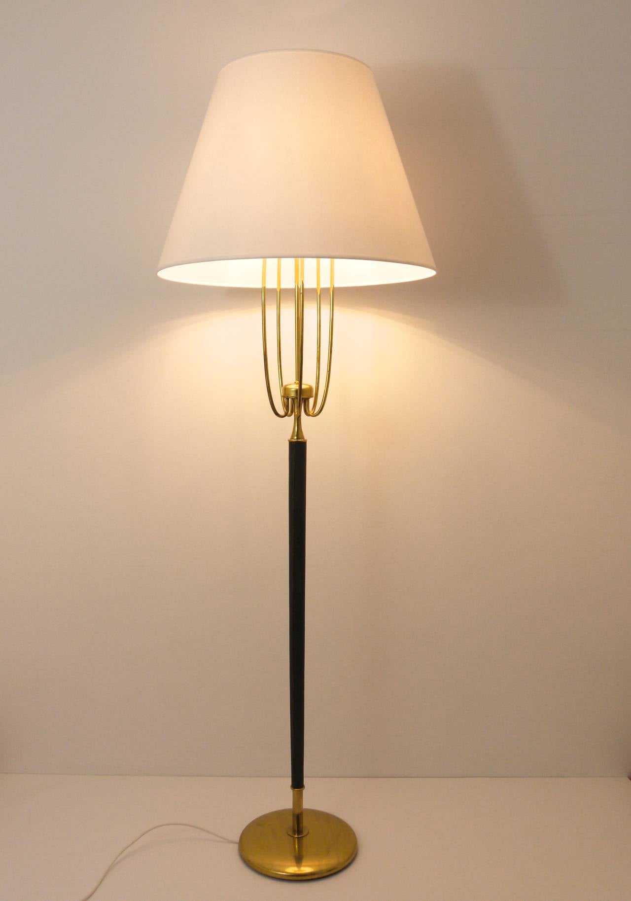 An elegant and unusual Austrian modernist floor lamp from the 1950s in the style of Josef Frank. Very beautiful, has five brass arms, a green, leather wrapped tapered stem and nice brass details. In very good condition with marginal patina.