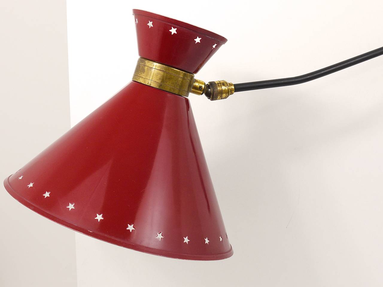 A beautiful articulating arm sconce by Rene Mathieu, France, 1950s. 180 degree adjustable, has a lovely star perforated red lampshade and nice brass details. In very good original condition with nice patina. Professionally rewired. 

Diameter of