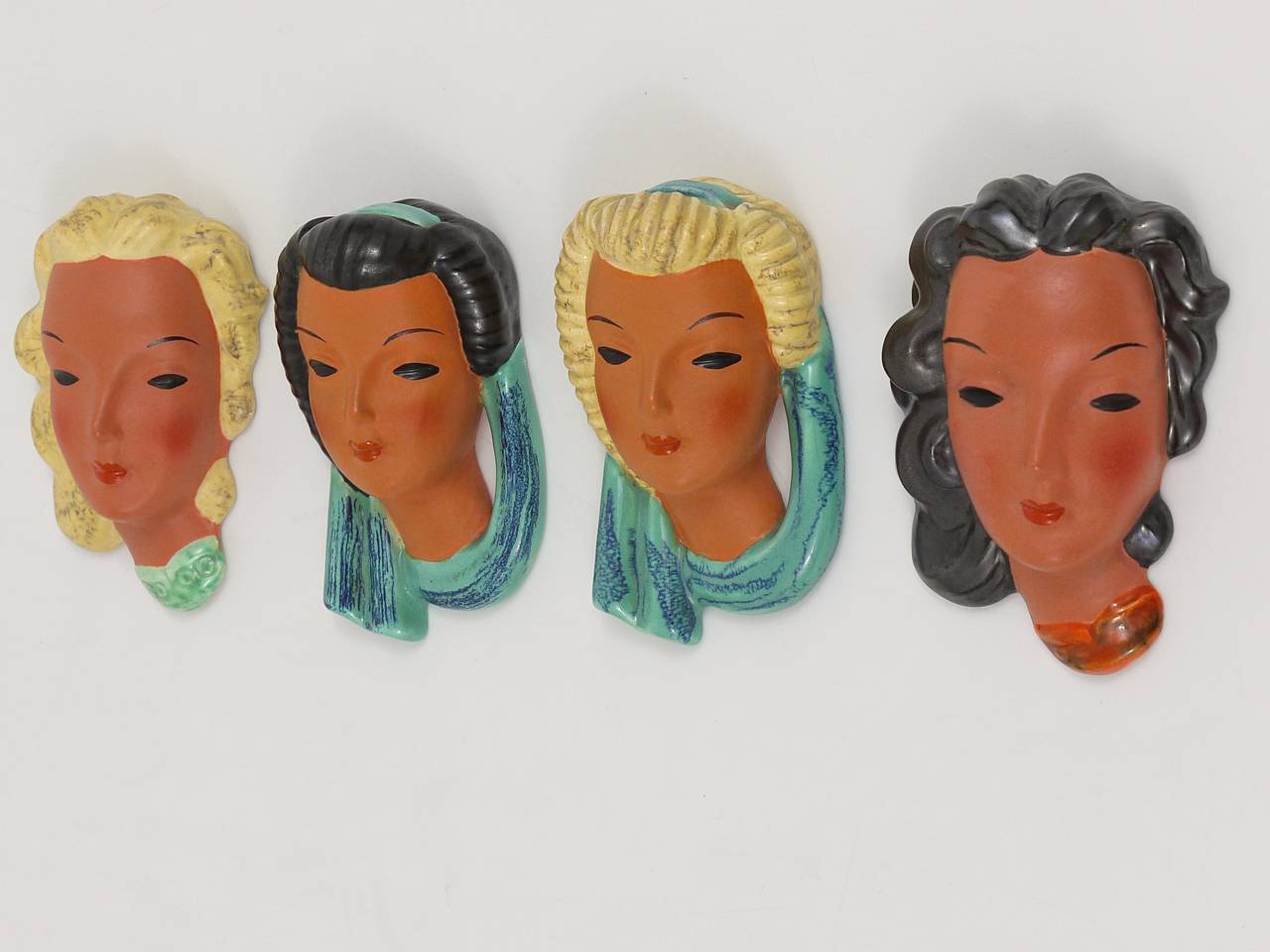 Ein schöner Satz von vier österreichischen Terrakotta-Miniaturwandmasken, entworfen von Adolf Prischl, ausgeführt von Friedrich Goldscheider Wien in den 1950er Jahren. Alle vier Masken sind in ausgezeichnetem Zustand. Markiert und nummeriert.