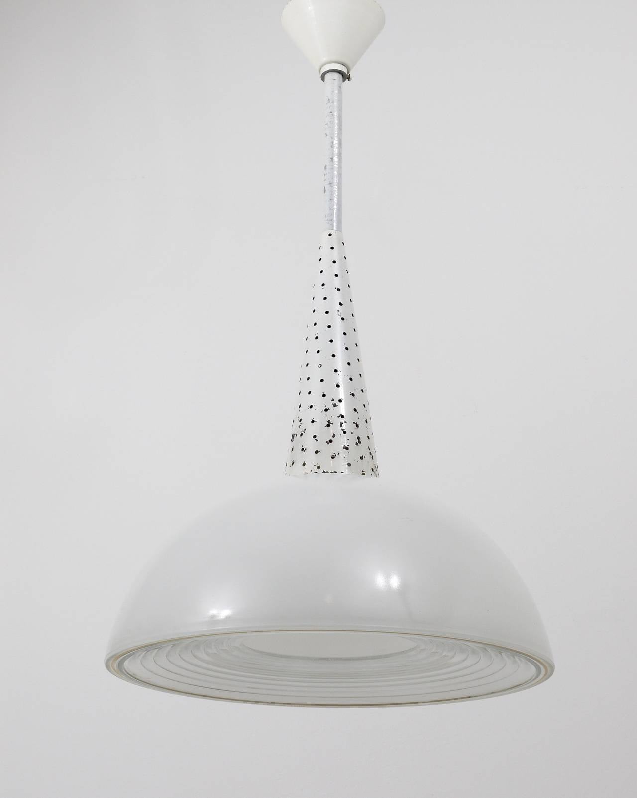 A beautiful industrial midcentury pendant lamp from the late 1940s / early 1950s, attributed to Mathieu Mategot for Holophane.  Made of white painted, perforated metal. It has a beautiful hemispherical lampshade with its original two-part prismatic