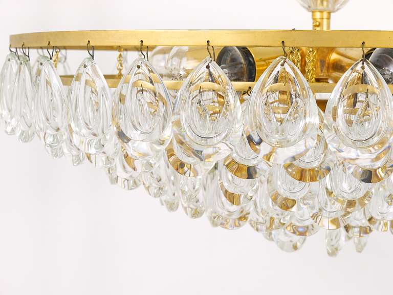 A very beautiful gold-plated crystal glass chandelier from the 1970s, executed by Palwa. Six tiers with optical lens teardrop crystal pendants. Has seven sockets. In very good condition with marginal patina on the brass. Diameter 20