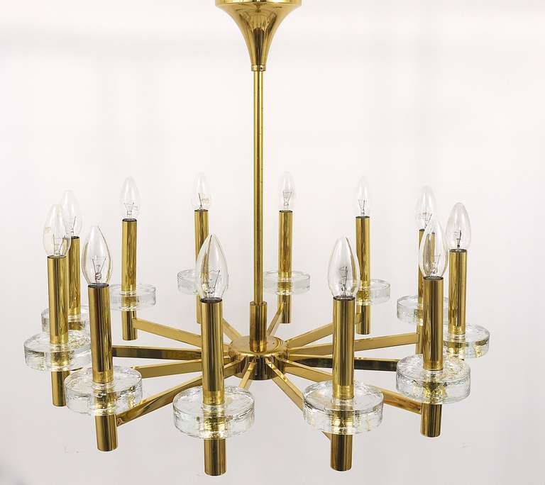 An outstanding Italian brass and crystal glass chandelier from the 1970s, in the style of Gaetano Sciolari. Has 12 arms, each candle is surrounded by a thick textured ice glass ring. In very good condition with marginal patina on the brass. Diameter