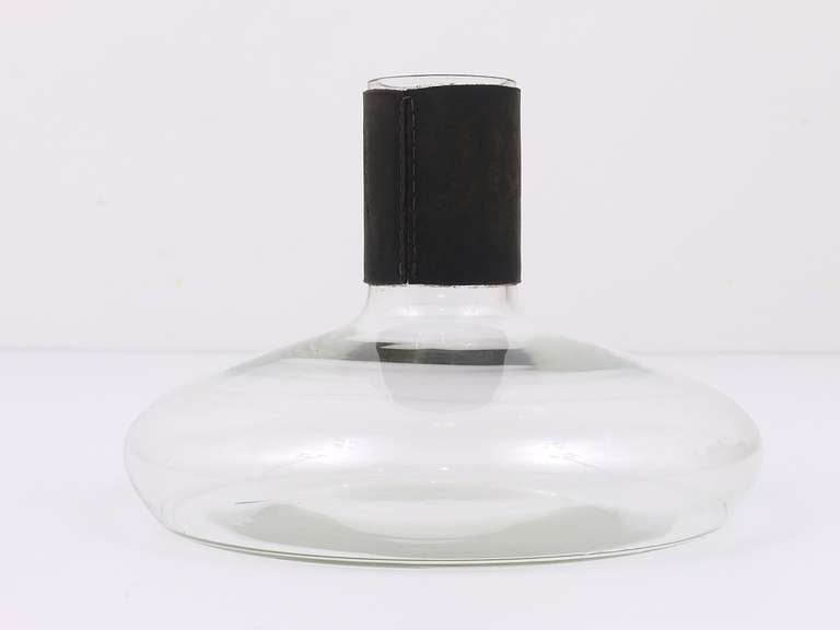 A beautiful Viennese modernist vase or decanter, designed and executed by Carl Aubock in the 1950s. Made of glass with nice black leather top. In very good condition, signs of age on the leather. Measure: Height 6 1/2 in, diameter 8 1/2 in.