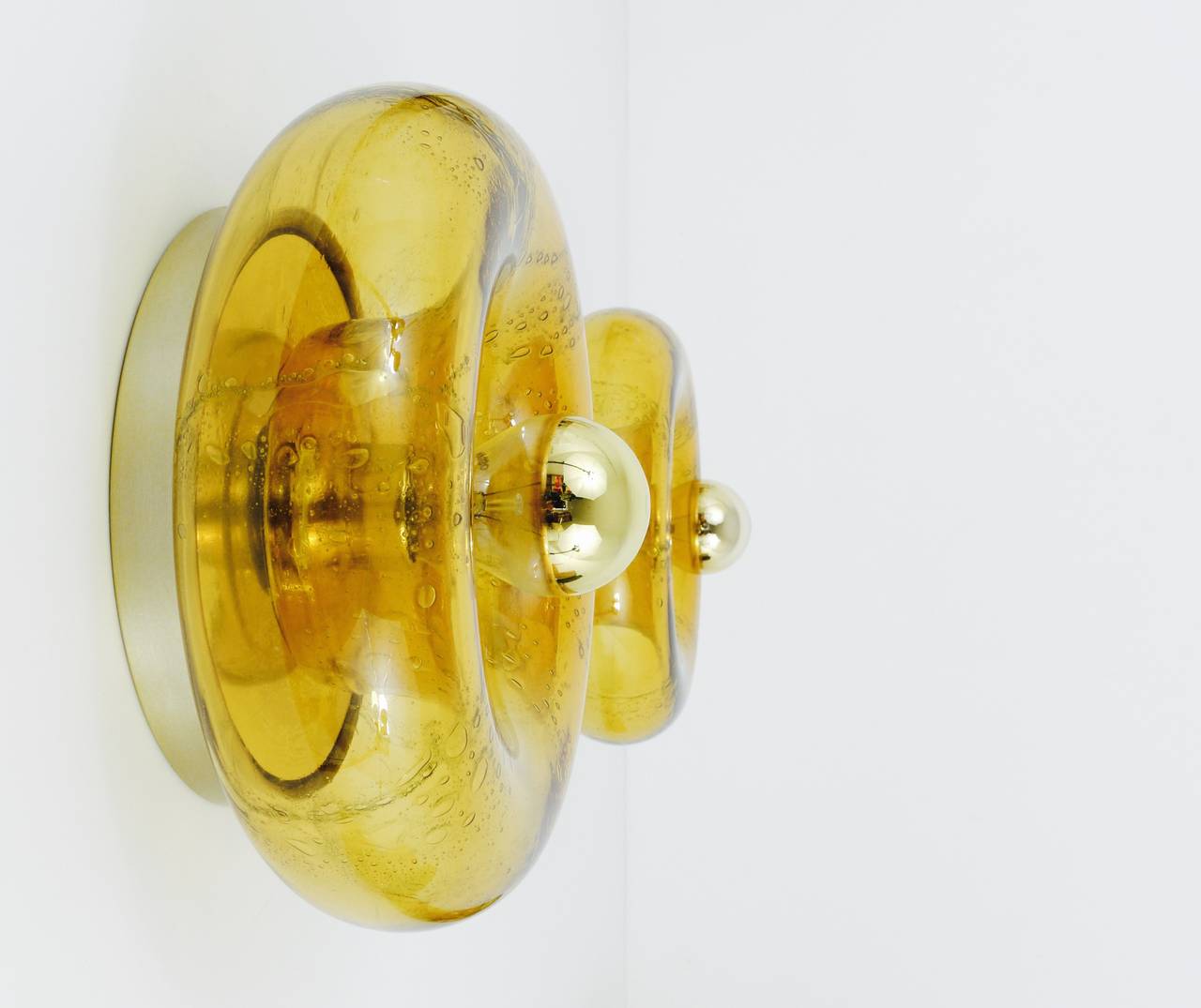 Une applique ronde en verre, réalisée par Doria Leuchten, Allemagne, dans les années 1970. Très belle pièce soufflée à la main en verre jaune ambré avec de belles bulles et une surface irisée. En parfait état. Une lumière magnifique. 