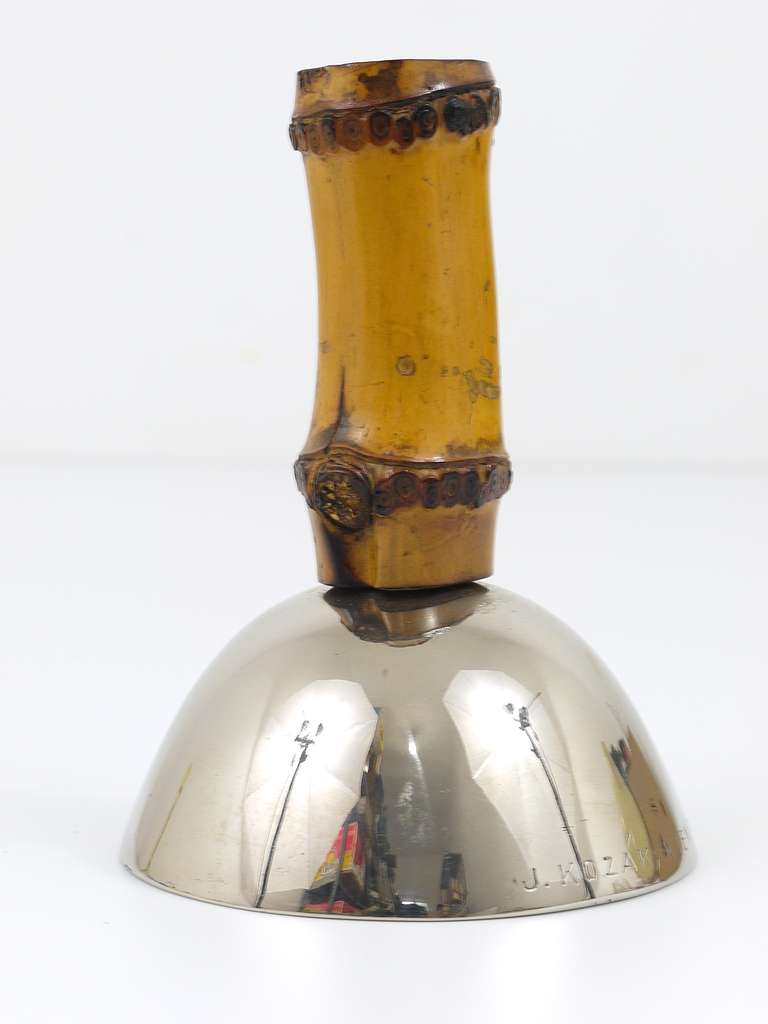 A rare and beautiful Viennese dinner bell, designed and executed by Carl Aubock, Vienna. Big version, made of nickel-plated brass with a bamboo handle. In good condition with charming patina. Height: 5 /14