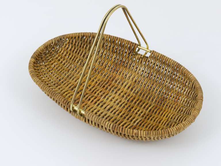 A very beautiful wickerwork fruit basket  with brass handle, designed and executed in the 1950s by Carl Auböck. In very good condition.  12x 8