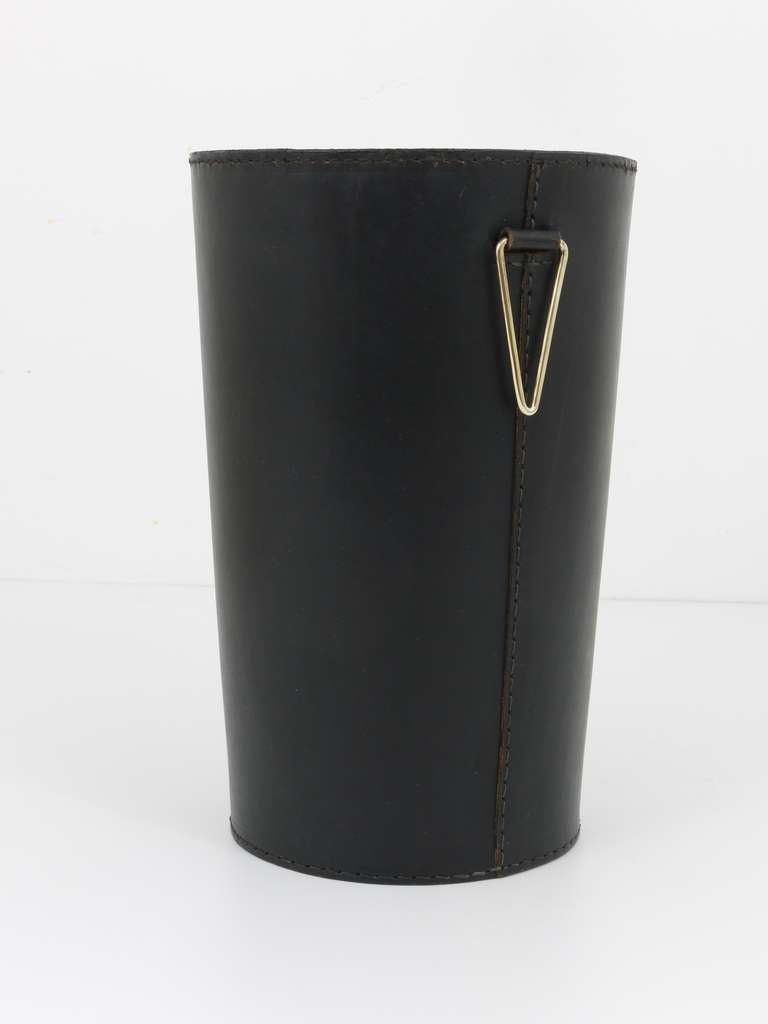 A beautiful elegant wastepaper, designed an executed by Carl Aubock, Vienna. Made of black leather with a nice brass detail. In good condition with charming patina on the leather.