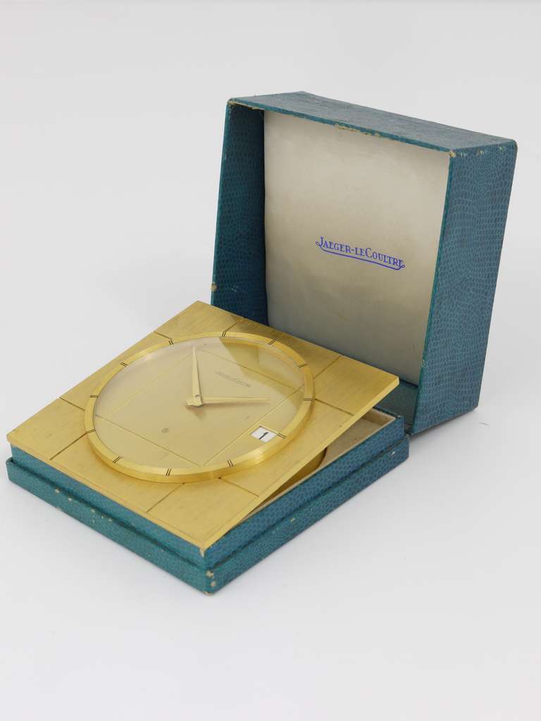 A very elegant Jaeger-LeCoultre desk clock with date display from the 1960s. Boxed, fully working, in good condition. Has a 8-days movement with quick-date-setting. 

Measures: 4 1/2 x 4 1/2 in, height 1 1/2 in.