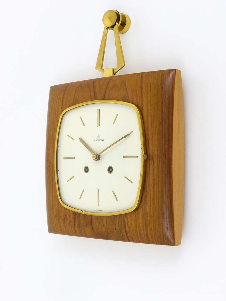 A beautiful modernist wall clock with wooden case and nice brass details from the 1950s, executed by Junghans Germany. Has an 8-day movement with two gongs, striking every half an hour. (Gong can be switched off). A very beautiful clock in excellent