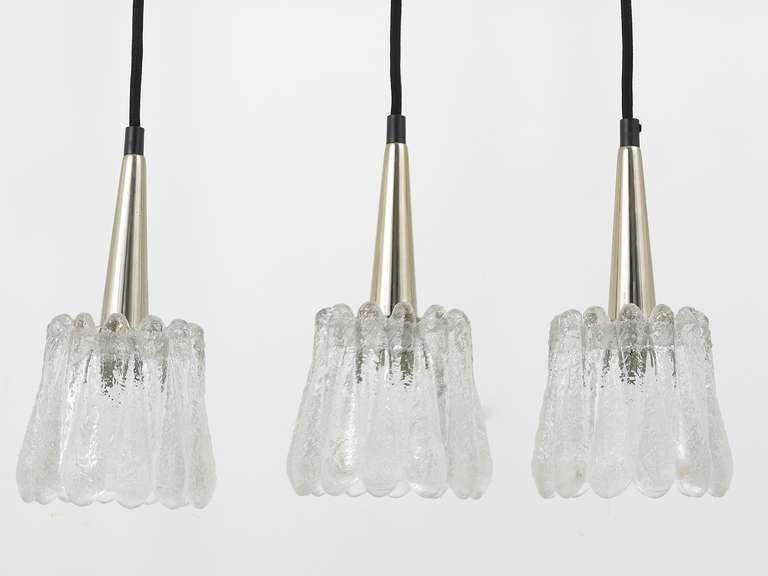 A set of three elegant pendant lamps from the 1960s, designed by Carl Fagerlund, executed by Orrefors Sweden. Beautiful frosted glass-lampshades with nickel-plated hardware. Recently rewired with black fabric cord. In excellent condition. 

diameter