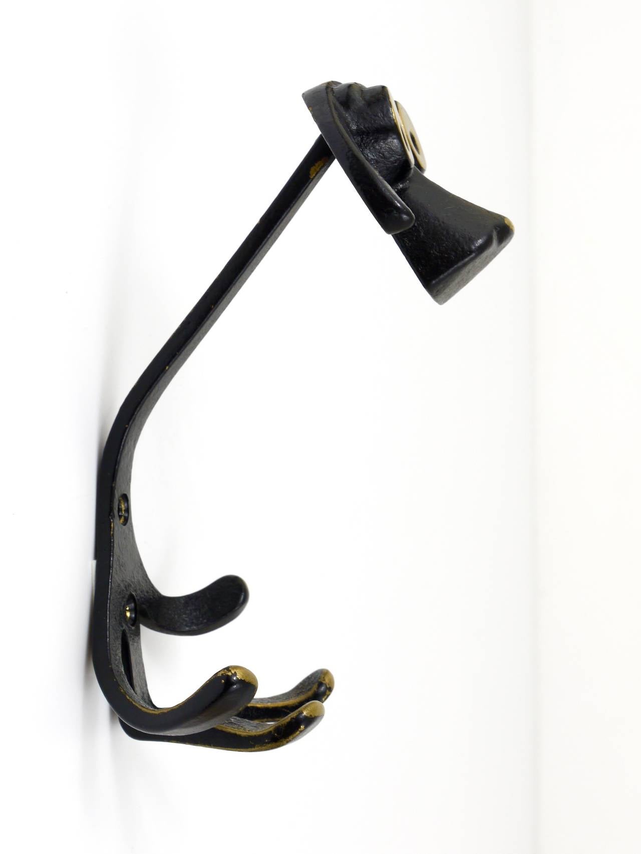 A set of two Austrian modernist brass wall coat hooks, displaying a dog. A very humorous design by Walter Bosse, executed by Hertha Baller Austria in the 1950s. Made of black finished brass. In very good condition with nice patina. Each hook has a