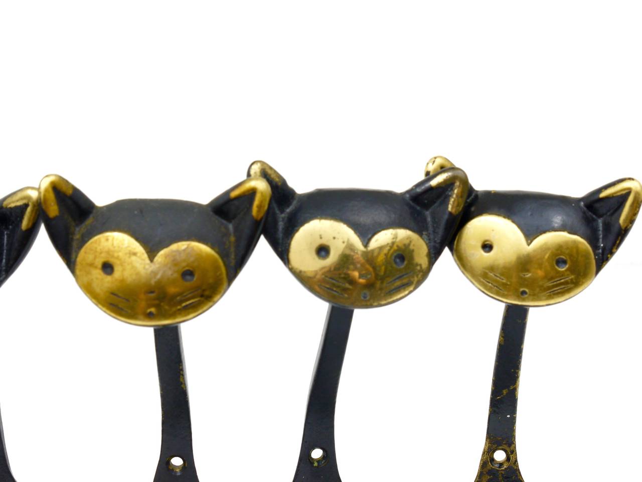 Up to eight Austrian modernist brass wall coat hooks, displaying a cat. A very humorous design by Walter Bosse, executed by Hertha Baller Austria in the 1950s. Made of black finished brass. In good condition with patina. Each hook has a height of 7
