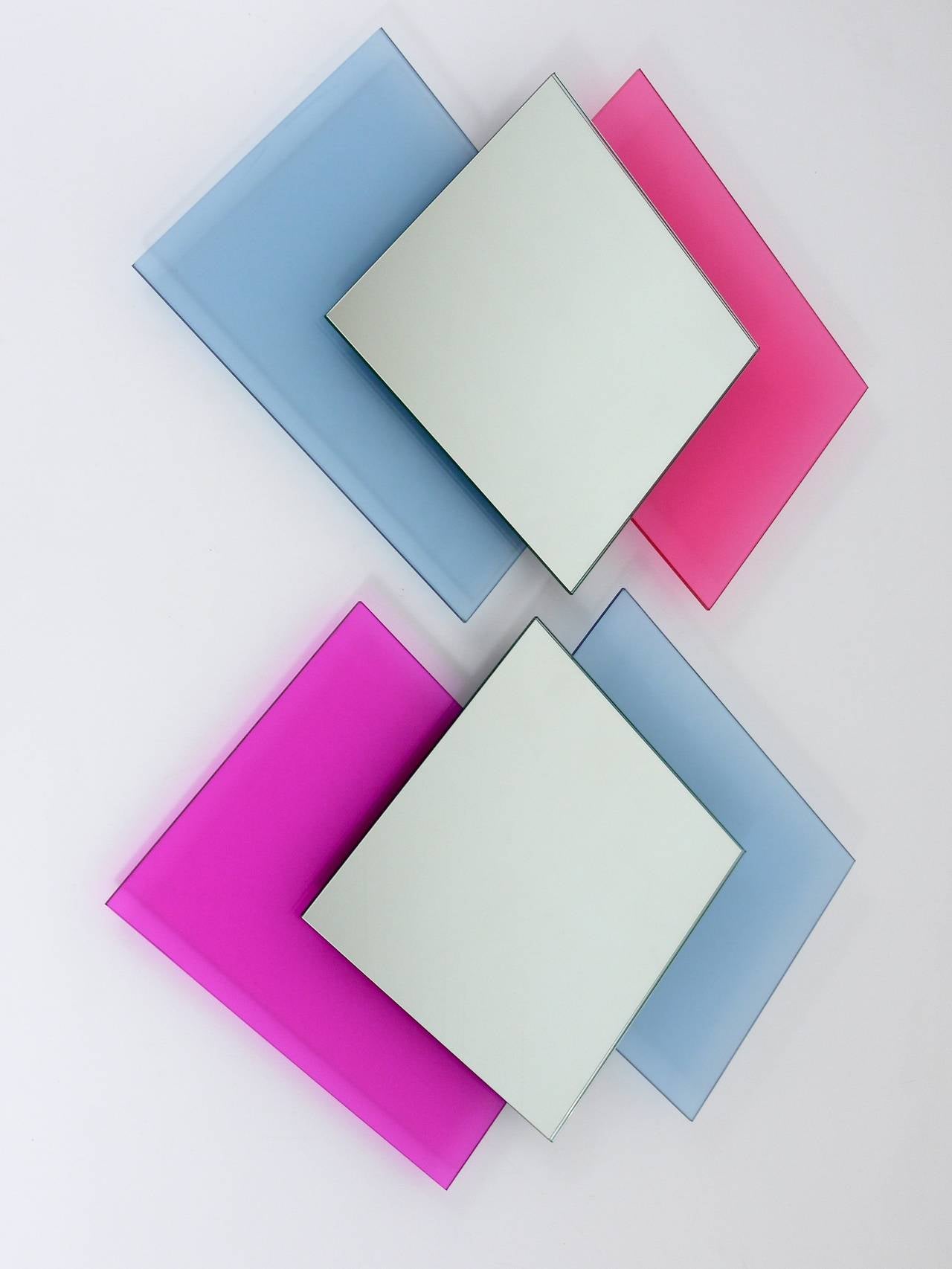 A pair of two matching, Italian wall mirrors from the 1980s in the style of Ettore Sottsass. Each mirror consists of two rectangular see-through glasses in light-blue and pink and a square mirror in the center. In excellent condition, sold as a pair.