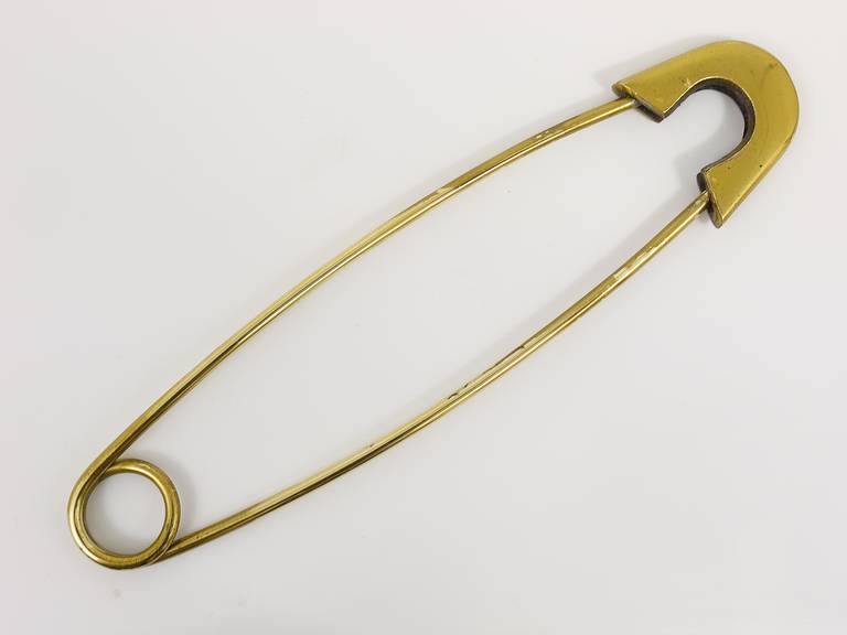 Very beautiful and decorative oversize brass fixing pin, to use as a paperweight. Designed and executed by Carl Aubock. Marked: Made in Austria. Measures: Length: 9 inches.