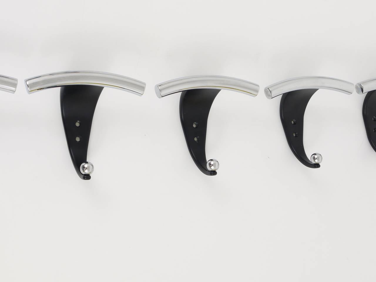A set of up to seven postmdoern Memphis style wall hooks, executed in Italy in the 1980s. Made of chromed and black metal. Very solid, in excellent condition. Sold and priced per piece.