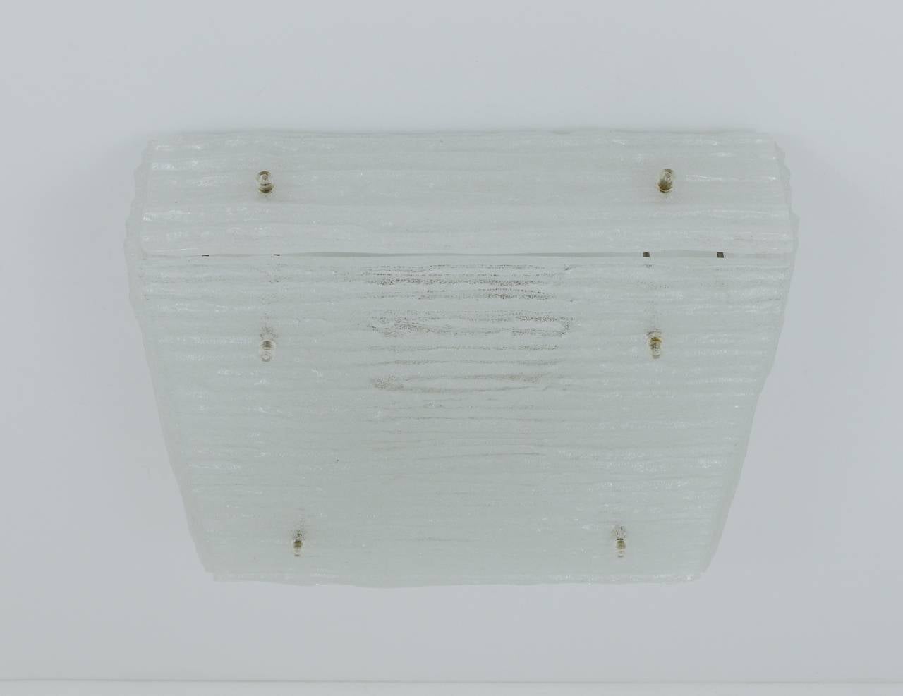 A beautiful square mid-century ceiling lamp, executed in the 1960s by Kalmar Vienna / Austria.  To use as a flush mount but also as a sconce / wall lamp. Made of solid textured ice glass on a white painted metal base. Has 4 sockets. In very good