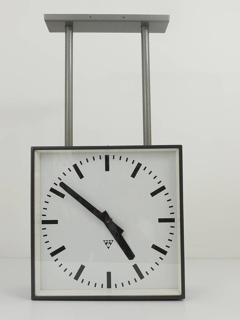 A very big loft industrial clock from the 1950s, to mount on the ceiling or on the wall. Very straight but beautiful design, this is a double sided clock with two clock faces. The housing is made of grey painted metal. Powered by two quartz