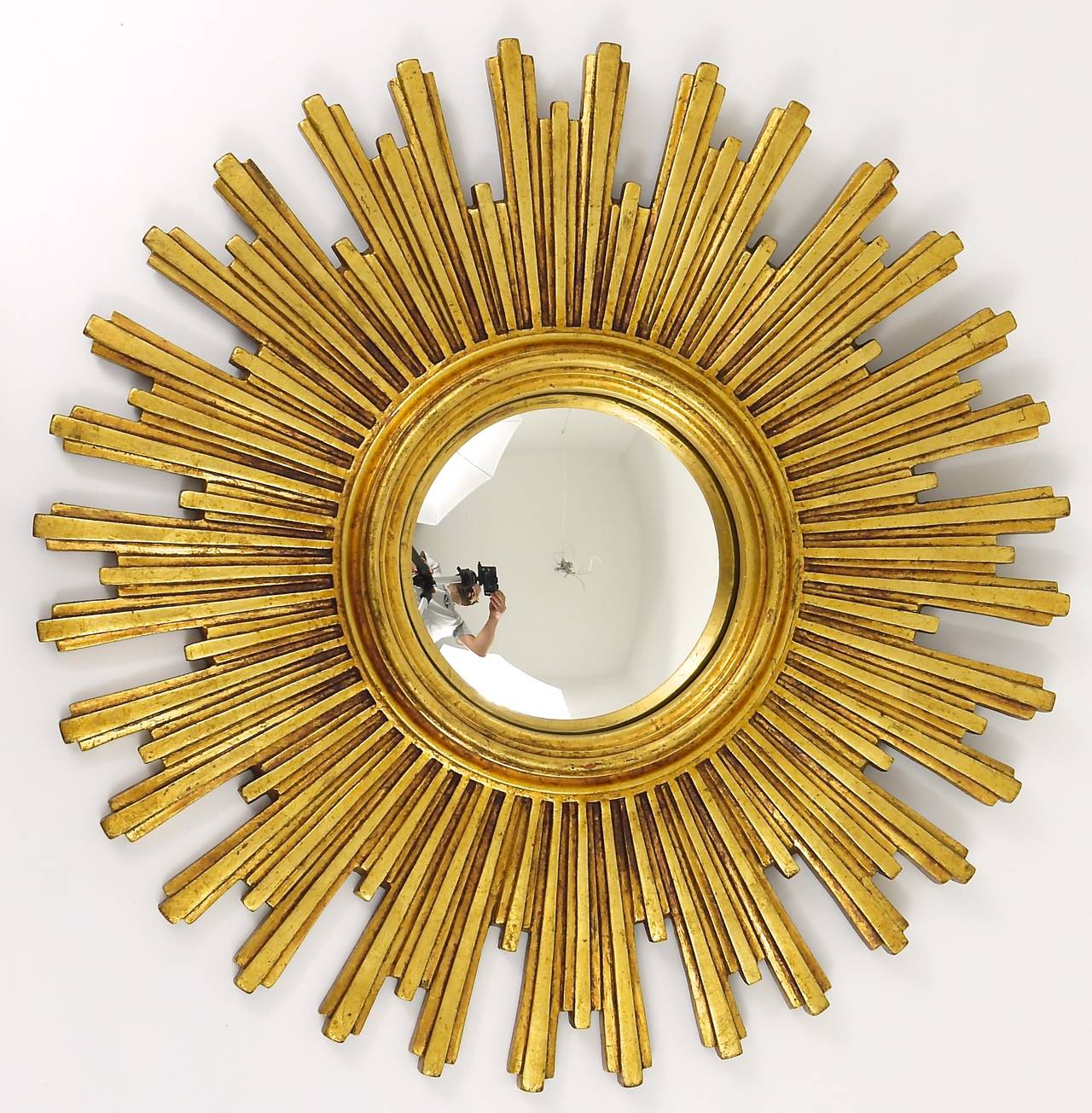 One of two beautiful and big sunburst/starburst gilt wall mirror with convex mirror glass from France, dated around 1950. A very beautiful and decorative object in very good condition. Diameter 22