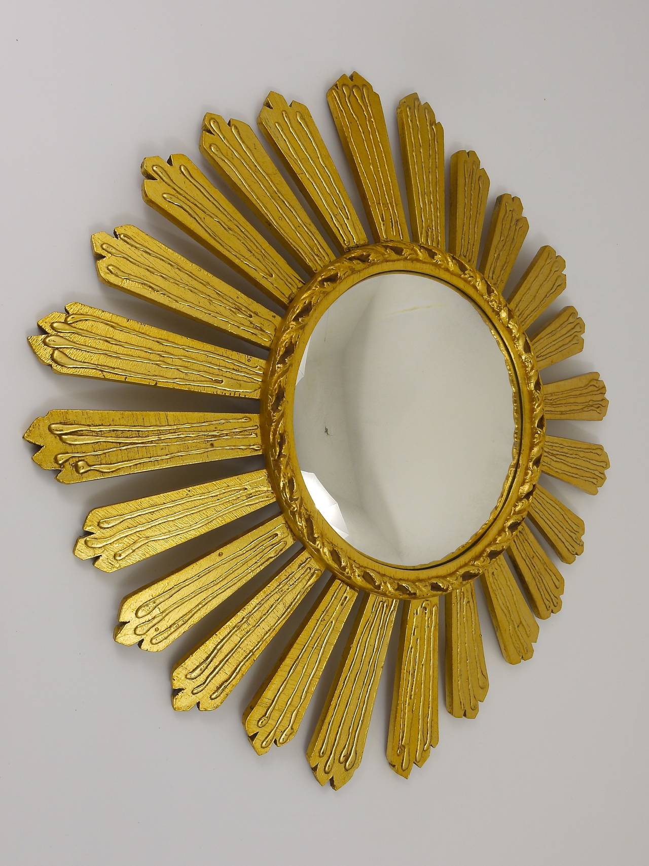 A beautiful and decorative sunburst/starburst gilt wall mirror with convex glass from France, carved wood, dated around 1950. A very beautiful and decorative object in very good condition. Diameter 26 in;. Right now we are offering many other