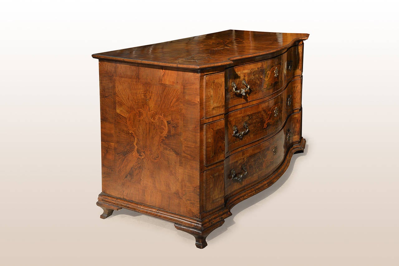 A very fine and rare Italian chest of drawers, mid-18th century.
Overall veneered and inlaid with walnut, maple and walnut burl.
Three drawers on the front over four moulded feet.
Sides, top and front decorated with cartouche motives.

Emilia