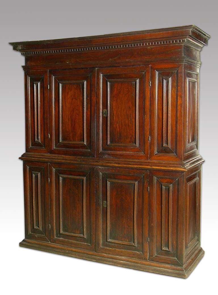 An Italian 17.th century walnut side cabinet.  The detailed cornice above a panelled and framed body with two central doors, the lower section with a further two paneled and framed  doors, over a moulded plint base.  Italy, first half XVII
