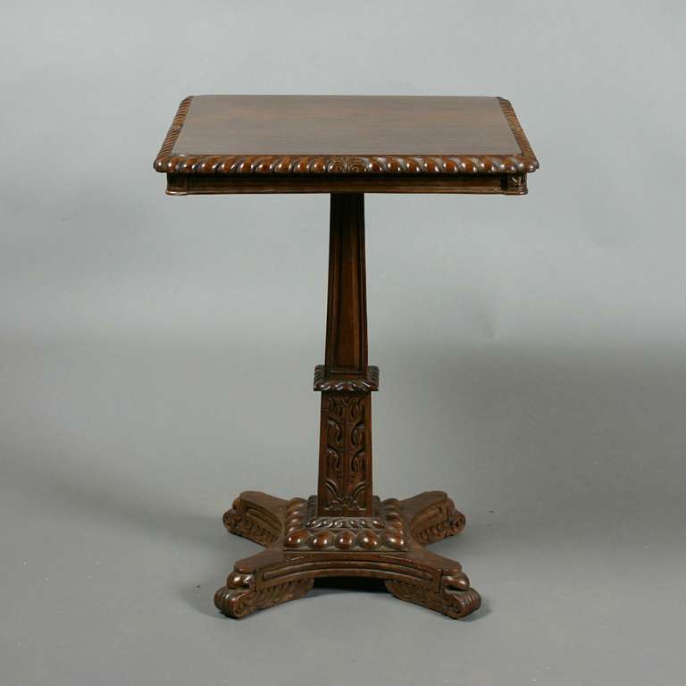 A carved 19th century Anglo-Indian rosewood central or occasional table, the square top with gadroon and leaf moulded edge, on a two stage carved stem and quatrefoil base with scroll legs.