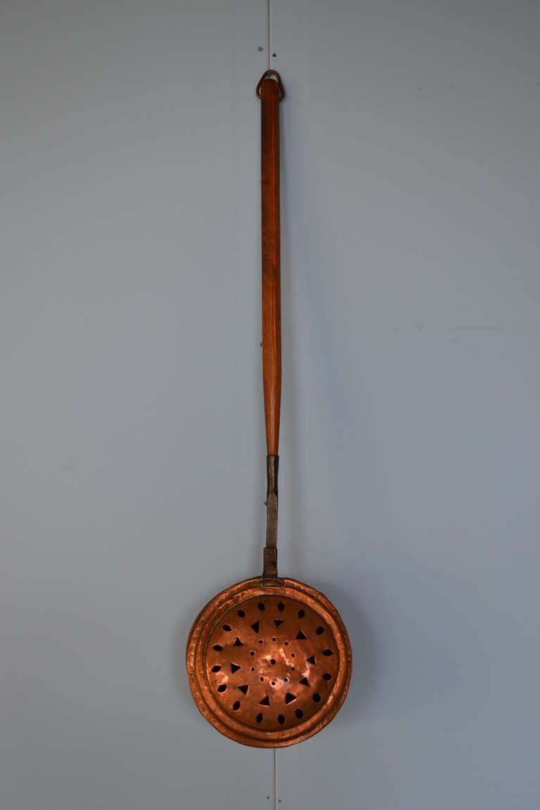 Diese seltene frühe und rustikale 18. Jahrhundert holländischen Kupfer handgefertigt Kastanienröster mit Holzgriff hat eine fantastische Patina. Der Deckel ist mit handgenähten Dreiecken und anderen Figuren verziert.