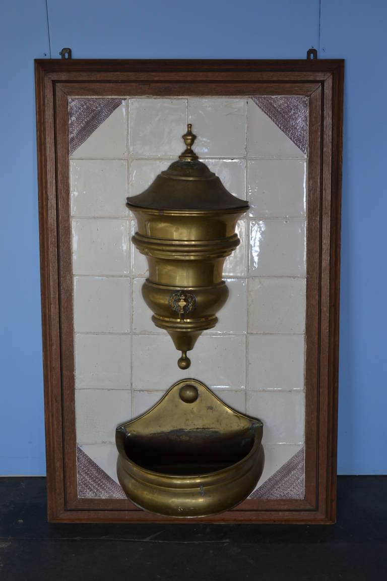 A rare 18th century Dutch brass lavabo mounted on original white and manganese tiles.

This elegant Dutch brass wall lavabo adds classic beauty to any setting.

The watertank with elegant faucet and catch-basin in great original working