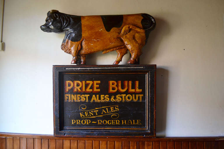 MH’s Department: Fine Folk Art throughout the  ages
Original pictorial painted  wooden pub sign crowned with a prize bull; this pub sign used to hand above the entrance of a country pub where different kinds of beer were sold as Ales & Stouts by