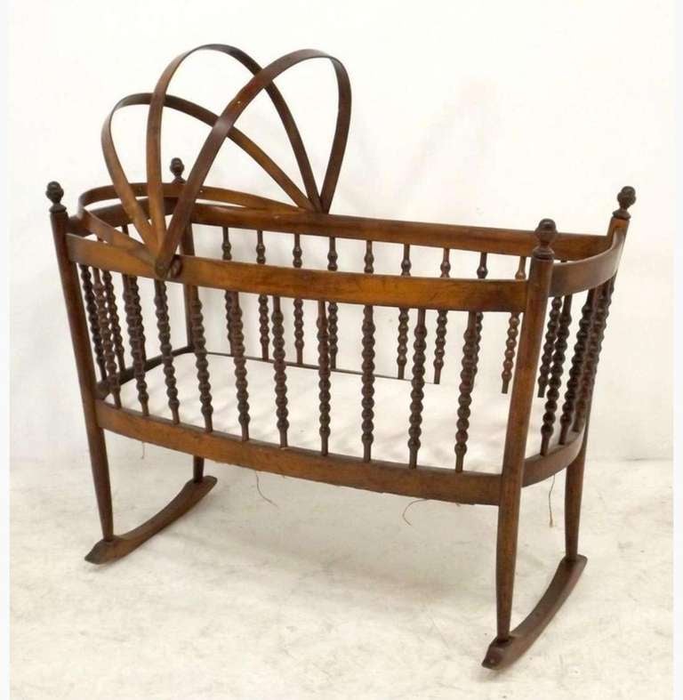 A 19th century Dutch stained beechwood cradle with turned spindles above a curved base raised on four circular form legs to shallow rockers

* The president of MH, second generation antiques dealers, started his career in 1968