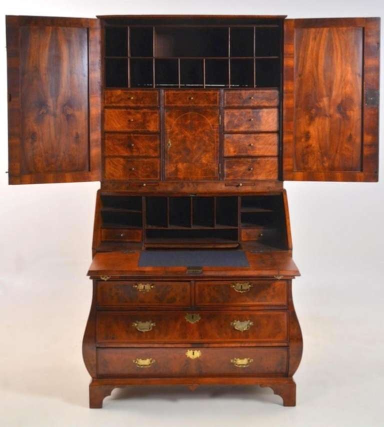 A diminutive early 18th century burr walnut and walnut crossbanded bombe bureau bookcase (circa 1720) with beautifully bookmatched burr veneers of the first quality; of outstanding color and patination, this piece with a straight moulded cornice