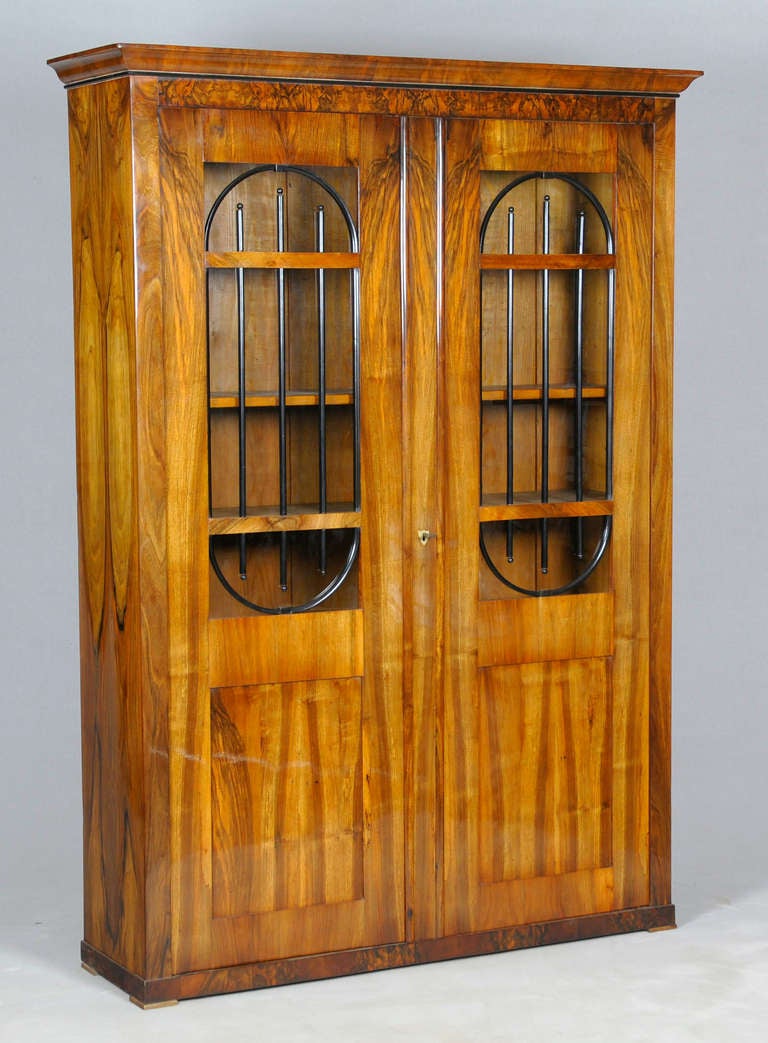 Biedermeier Showcase (bookcase) 

    - walnut veneer,

    - Biedermeier, Austria around 1825,

    - Shellac French polish.

Very rare books cabinet with ebonised transom window

Country of Origin: Austria
year of construction: