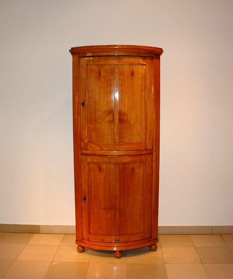 Biedermeier corner cabinet

    - Biedermeier 1830

    - Cherry Wood

    - Classic, closed body

    - One door top and bottom

    - With shelves

    - French polish

Country of Origin: Germany
year of construction: