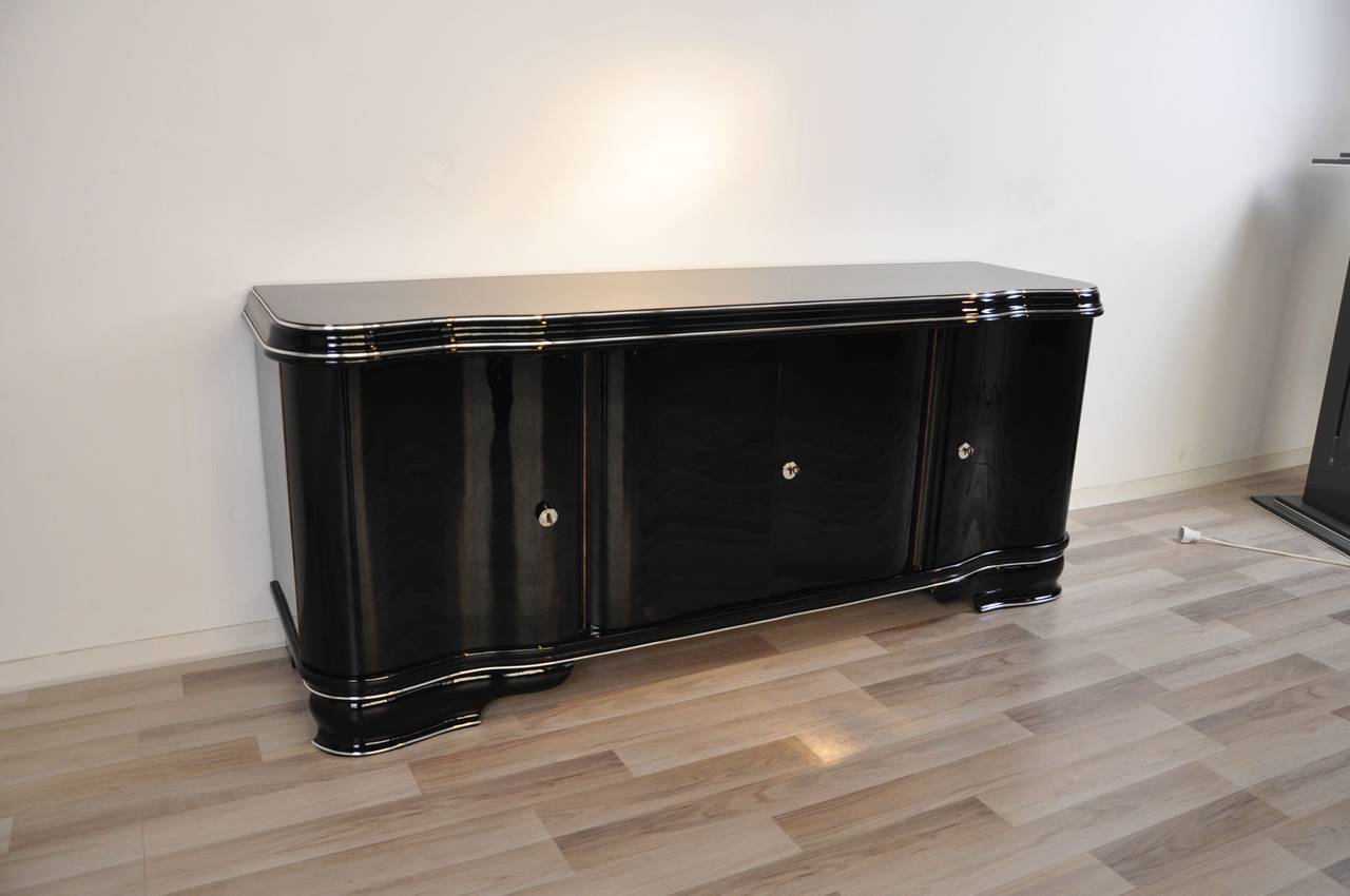  Art Deco lowboard with a simple but elegant design. The exterior got finished with our signature high gloss black paintjob while the interior is painted with a matte black lacquer. This piece of furniture offers two curved and two straight doors