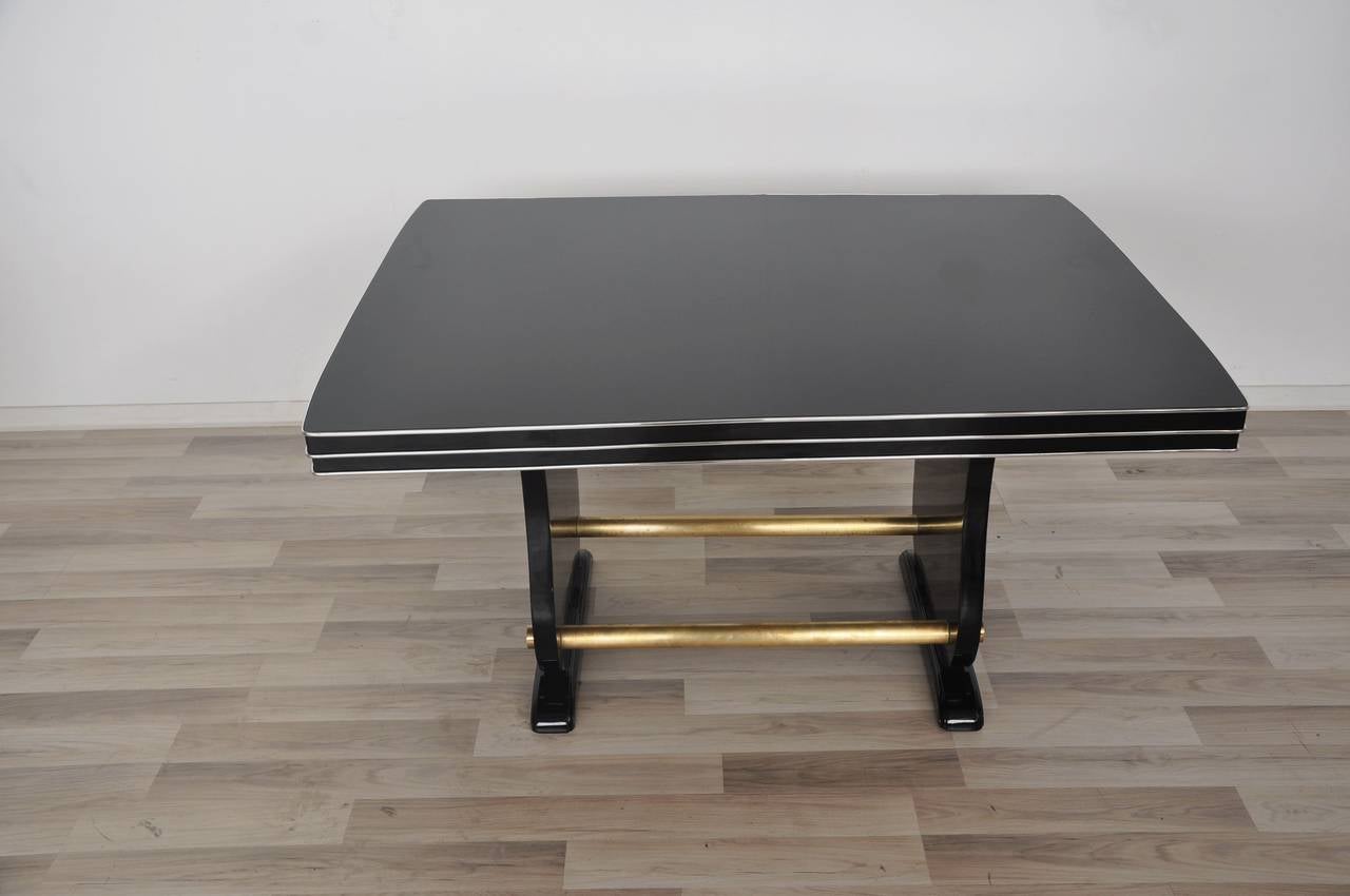 Wonderful Art Deco living room table or dining table with beautiful brass and chrome details. Extraordinary formed feet’s and a hand polished tabletop. Restored in 2017 in our manufactory.

High quality piano lacquer with up to ten layers
Great