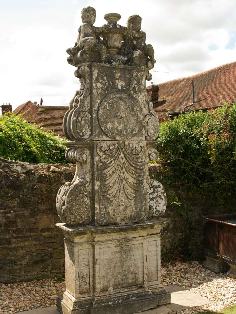 Reputedly of royal provenance. The top with cherubs flanking an urn, below the dial a large palmette, on a breakfront column base.