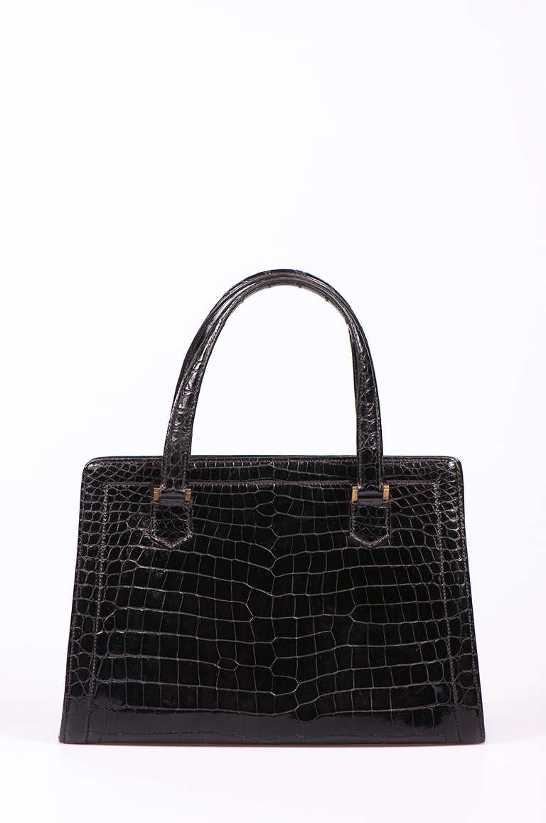 A BLACK CROCODILE 'PULLMAN' BAG 
HERMÈS. 
Gilt metal hardware, with double handle and lockable interior compartment, with key fob.Stamped 'HERMÈS, PARIS' to interior