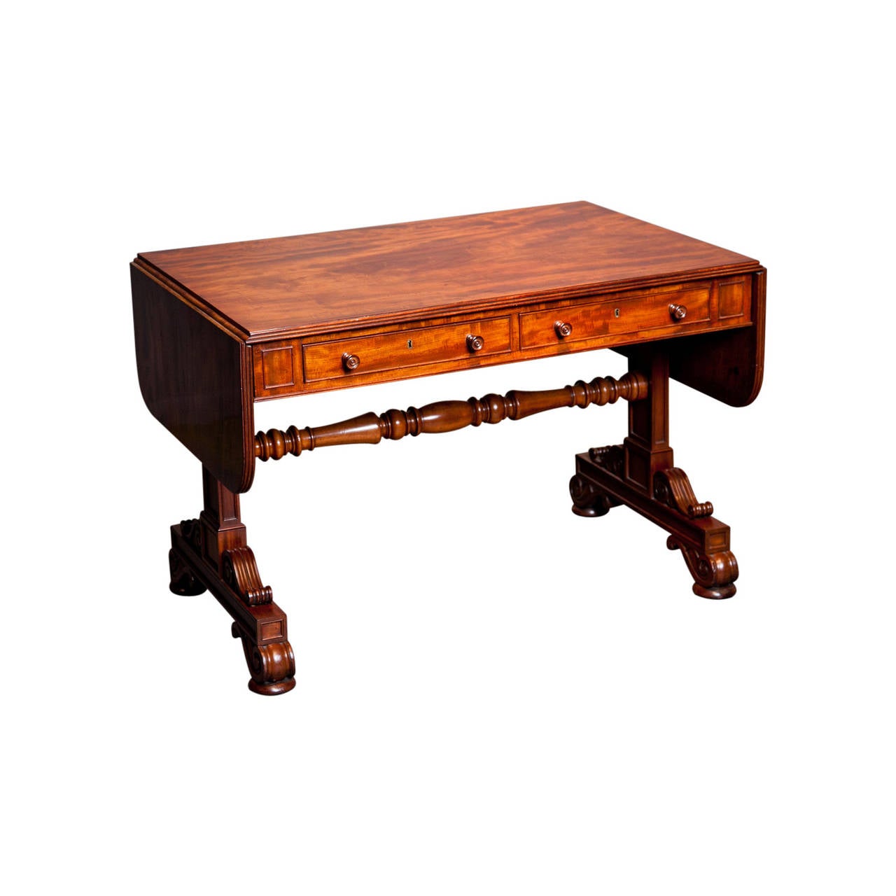 Crafted by Gillows of Lancaster, this exceptional, stamped sofa table exhibits a luminescence only found in mahogany pieces of the highest quality and grain.

 The drop-leaf table employs extremely precise dovetail joints at each side, while the