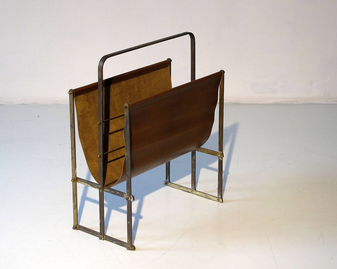 Mid-Century Modern, most probably Austrian 1950s magazine rack.
Structure in solid brass with leather sling. Leather has been replaced.
The brass structure is held together by numerous screws, showing this object has been entirely handmade.
