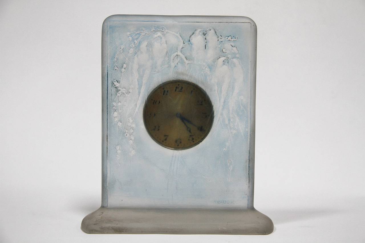René Lalique working glass six Hirondelles Perchees clock with blue stain.
Pendulette eight jours
modele cree en 1920
verre blanc moule-presse patine satine (moule n 1317)
haut. 15 cm
figure aux catalogues de 1928 et de 1932
supprime du