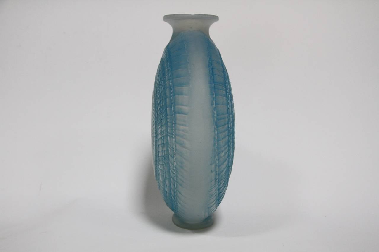 Rene Lalique Escargot Glass Vase With Blue Stain
modele cree en 1920
verre blanc souffle-moule presse simultanement, 
opalescent et couleur (moule n 1399)
haut. 22 cm
figure aux catalogues de 1928 et de 1932
supprime du catalogue en 1937
non