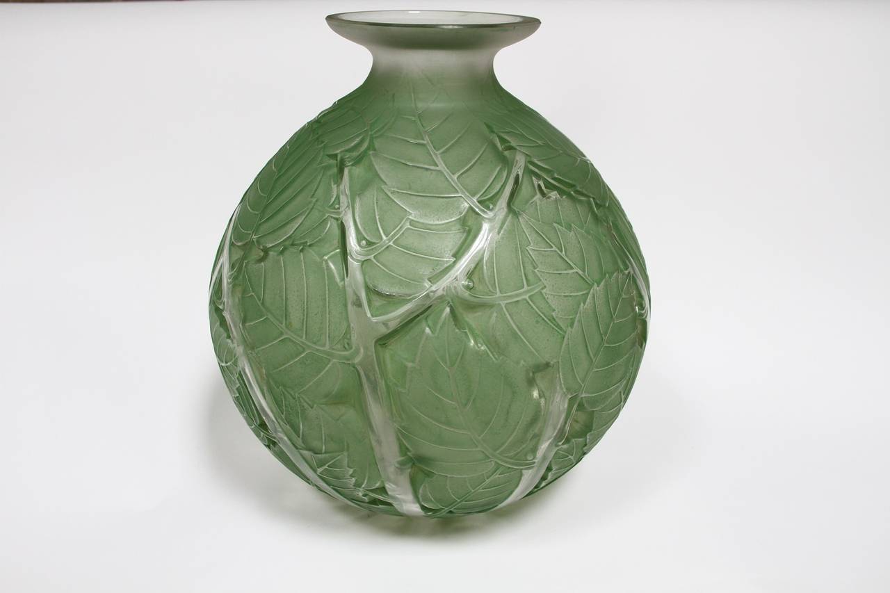Rene Lalique Milan glass green stain vase, 
dit aussi vase - Feuilles et branches polies,
modele cree le 17 jun 1929,
verre blanc souffle-moule patine et couleur, 
haut 28.6 cm,
figure au catalogue de 1932 et sur le tarif de 1937,
epuise le 28