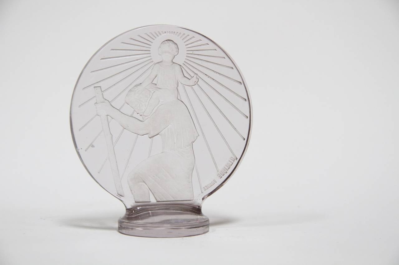 René Lalique glass Saint-Christophe Car Mascot.
presse-papiers
modele cree le 1 mars 1928
verre blanc moule-presse
haut. 13 cm
figure aux catalogues de 1928 et de 1932 et sur le tarif de 1937
non continue apres 1947
- existe en version