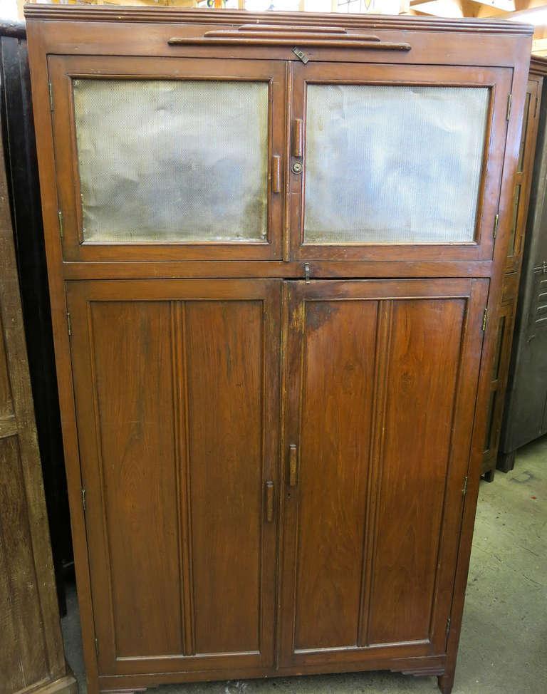 This antique Burmese teak cabinet would have originally been used as a Pie safe and kitchen pantry.  The top doors are mesh to allow for ventilation and their is a lock (no key) to keep the pies safe.  The bottom doors open to reveal  lots of