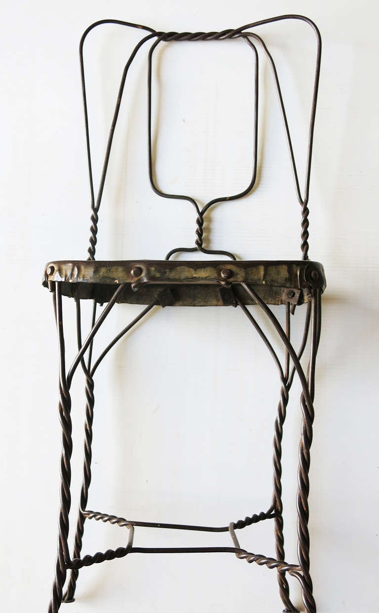 This is a twisted wire, machine age, ice cream parlor soda fountain chair from the period 1920 to about 1940.  We have about 50 of these with some variations on the style that we purchased in India.  This particular one has an elephant motif on the