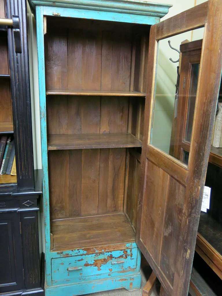 This piece is painted with an amazing shade of blue and in places reveals the rich Burmese teak wood underneath. The construction dates from the early 20th century when it would have been used as a pantry cabinet.