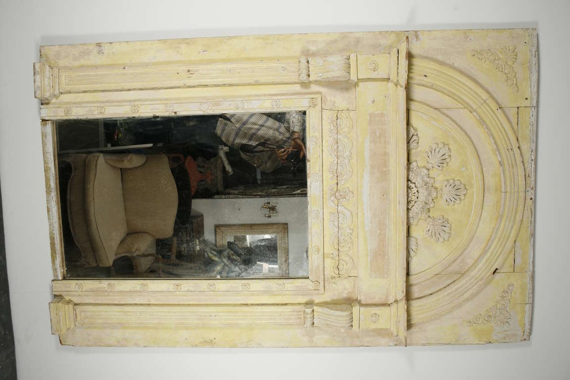 A large trumeau mirror of yellow-painted wood and modeled plaster, meant to be placed above a fireplace
Made in France, c. 1800
