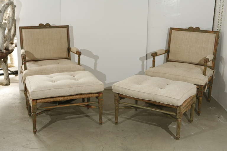 A pair of Louis XIV-style pailles fauteuils with footstools.

Painted, carved wood framework, with woven straw bottoms and freshly upholstered cushions 

French, late 19th. century - excellent condition and very comfortable

Stool measurements are
