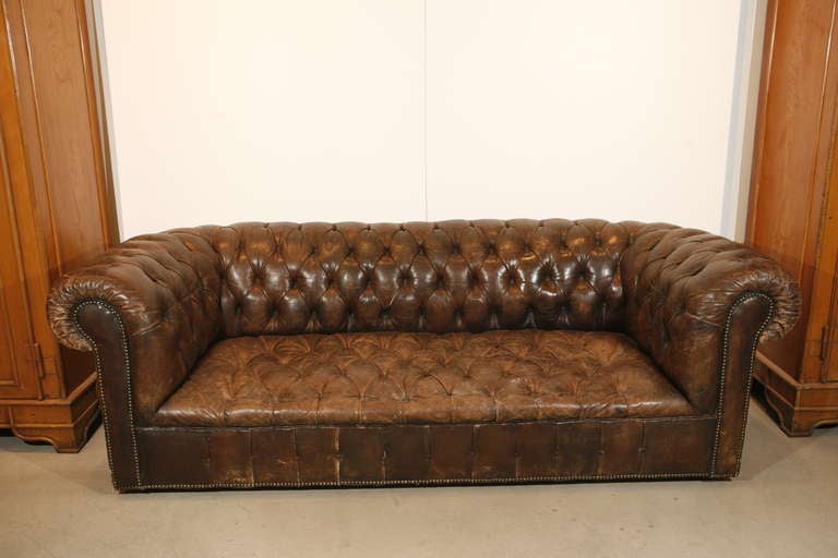 A chesterfield style club sofa with original leather upholstery

French, early 19th century