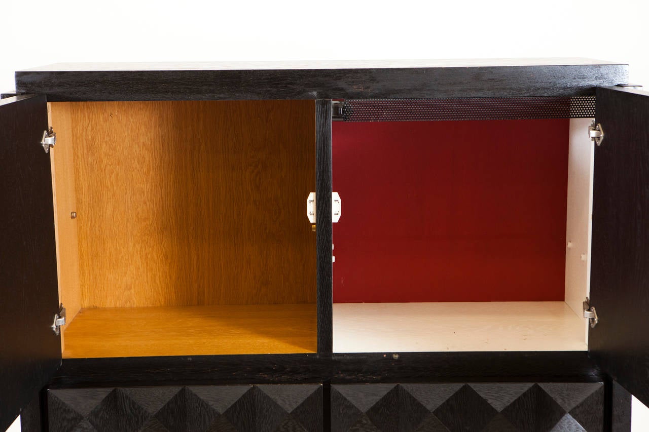 An ebonized Belgium Brutalist style bar cabinet with graphic front door with detail of checkered pattern. Four doors with one cube painted white/red accent with others in natural oak finish. Interior wiring set for European standards.